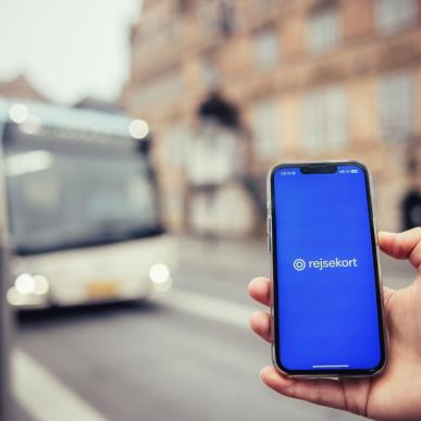 Rejsekortet på mobil foran busstoppested